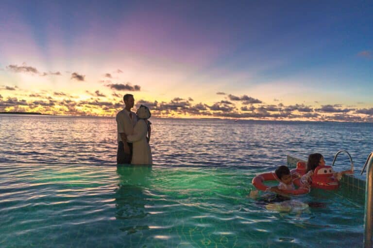 Family by the pool at sunset